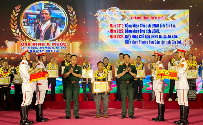  Lãnh đạo Quân khu 5 trao bằng khen tặng ông Đinh A Muốc, dân tộc Ba Na ở làng Pờ Nang, xã Tú An, thị xã An Khê, tỉnh Gia Lai. Ảnh: KIM NGÂN 