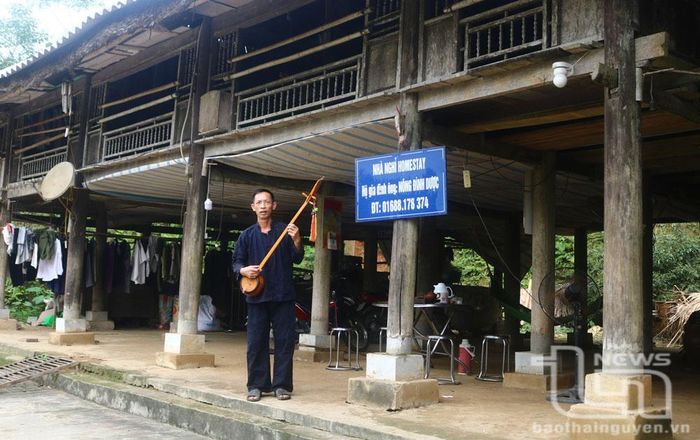 Ông Nông Đình Dược chào đón du khách với cây đàn tính.