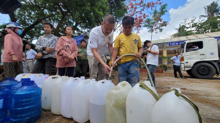 Ông Nguyễn Duy Hưng, Chủ tịch Ủy ban Đối ngoại Tập đoàn Tân Hiệp Phát tiếp nước từ xe bồn qua can nhựa