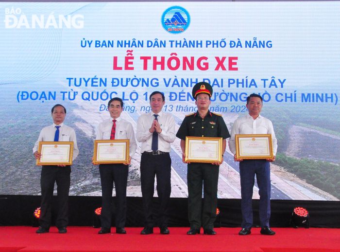 Chủ tịch UBND thành phố Lê Trung Chinh (giữa) tặng Bằng khen của Chủ tịch thành phố cho các đơn vị có thành tích trong thi công, giám sát dự án, đền bù giải phóng mặt bằng. Ảnh: THÀNH LÂN