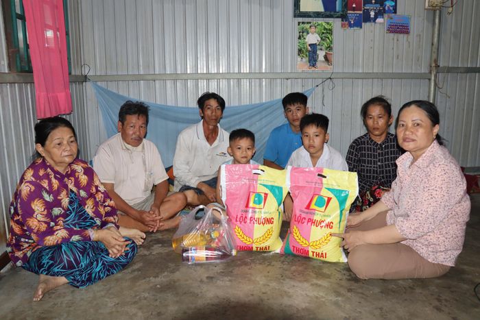 Bà Tám Hoa (bìa phải) tặng nhu yếu phẩm cho gia đình anh Hiền.