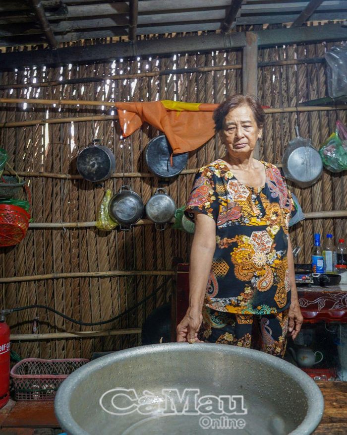 Mỗi khi trời mưa là bà Nhị lại phải hứng nước mưa dột trong nhà.