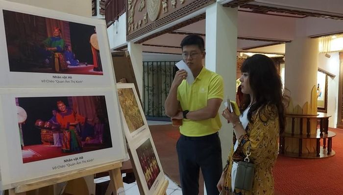 Tình nguyện viên giới thiệu về hề chèo qua ảnh triển lãm trước sự kiện 'Phi hề bất thành chèo'. Ảnh: Bình Thanh 