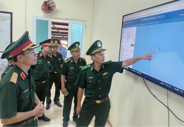 Thiếu tướng Hoàng Hữu Chiến (ngoài cùng, bên phải) giới thiệu công tác quản lý tàu đánh cá trên hệ thống điện tử tại cảng cá Hòn Rớ. Ảnh: Lệ Giang