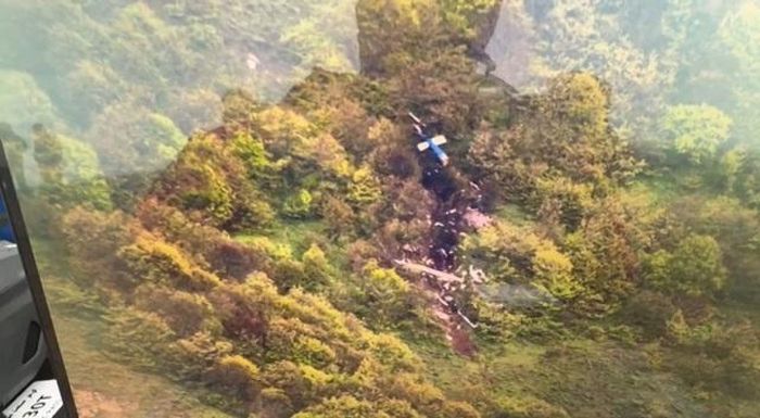 Lực lượng cứu nạn phát hiện xác trực thăng cháy rụi trên một sườn núi - Ảnh: AFP