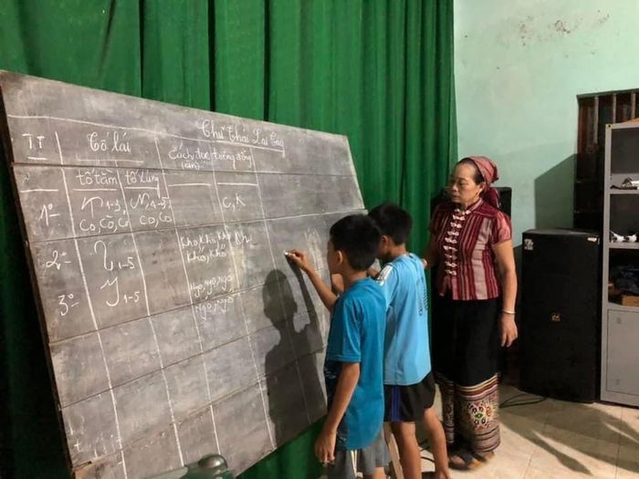 Nghệ nhân Ưu tú Sầm Thị Xanh truyền dạy văn hóa dân tộc Thái cho các em học sinh tại địa phương. Ảnh: Thu Hương
