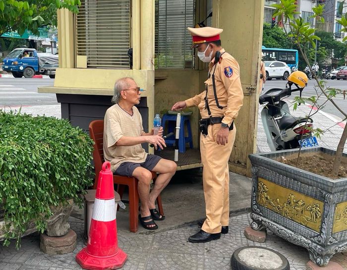 Cảnh sát giao thông giúp đỡ cụ Hùng. Ảnh: Chu Dũng
