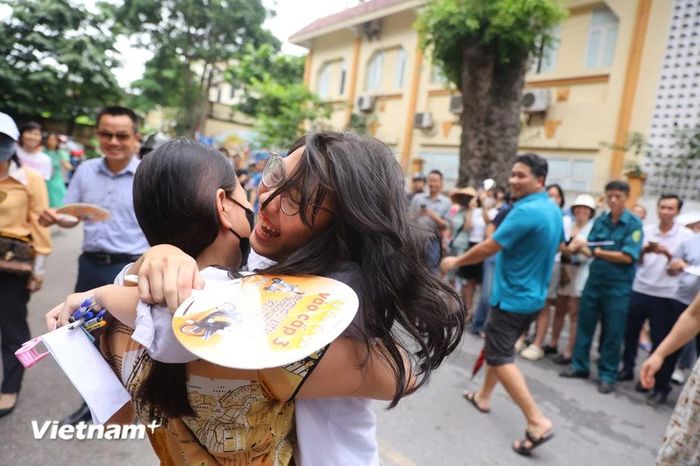  Thí sinh hạnh phúc ôm chầm lấy người thân sau khi hoàn thành tốt môn thi đầu tiên. (Ảnh: PV/Vietnam+) 