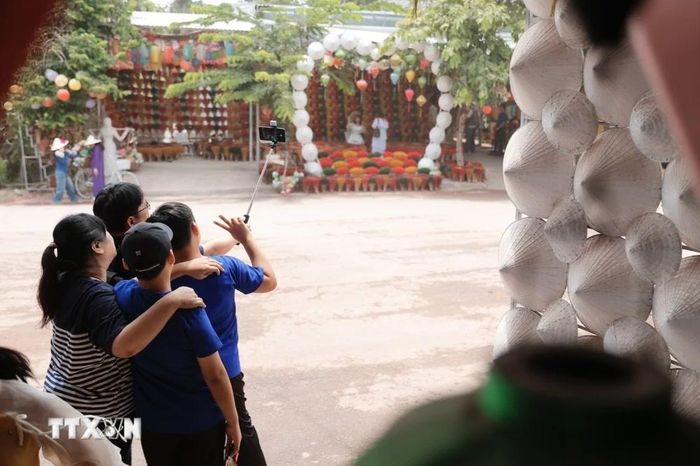  Du khách khi đến Thủy Xuân đều thích thú chụp ảnh với không gian đa sắc màu. (Ảnh: Đinh Ngọc Liên/TTXVN) 