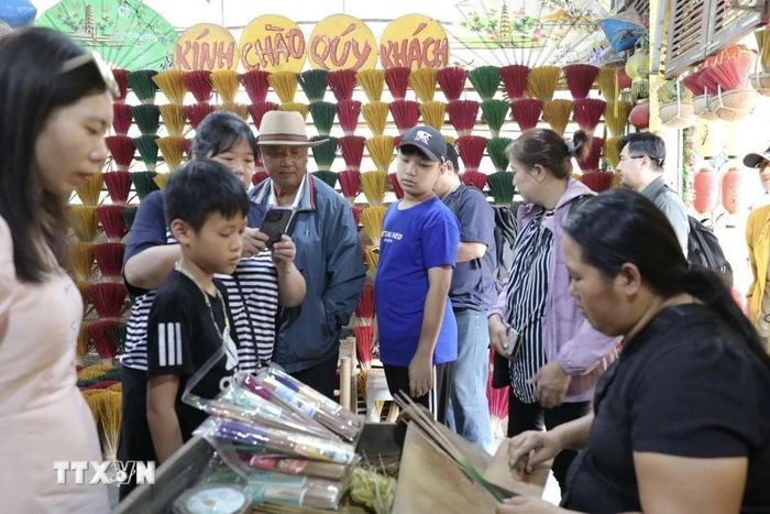  Du khách đến tham quan làng hương Thủy Xuân. (Ảnh: Đinh Ngọc Liên/TTXVN) 