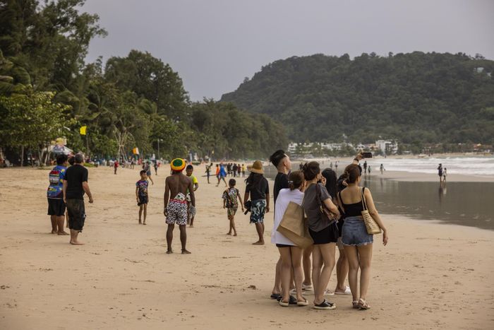  Khách du lịch chụp ảnh selfie trên bãi biển Patong ở Phuket, Thái Lan. Ảnh: Bloomberg. 