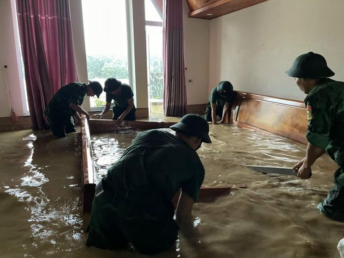 Cán bộ, chiến sĩ Tiểu đoàn Huấn luyện - Cơ động, BĐBP tỉnh giúp đỡ vận chuyển vật dụng gia đình bị ngập úng. Ảnh: Tiến Thắng