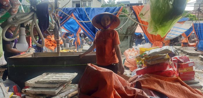 Chị Nguyễn Thị Đảm bên quầy hàng tan hoang.