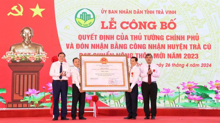 Lãnh đạo huyện Trà Cú, tỉnh Trà Vinh đón nhận Bằng công nhận huyện nông thôn mới. Ảnh: Trúc Phương.