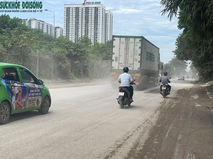 Người và phương tiện xe máy chật vật di chuyển qua khu vực khói bụi mù mịt.
