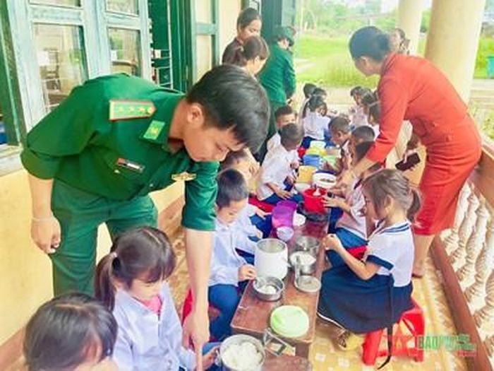 Cán bộ Đồn Biên phòng Thuận và giáo viên Trường Tiểu học Thuận, xã Thuận (Hướng Hóa, Quảng Trị) chia canh thịt cho các em học sinh. 