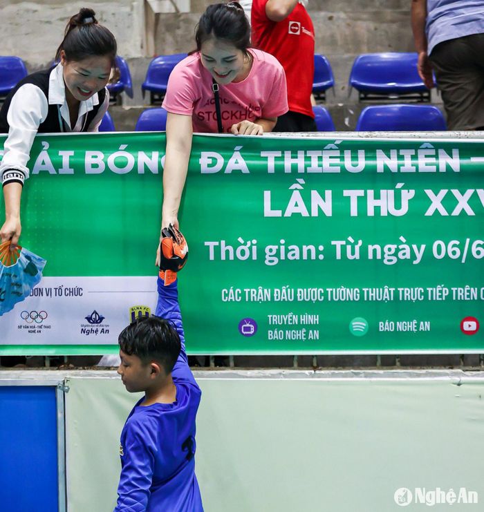 Cái chạm tay trong giờ giải lao của thủ môn Bùi Nhật Duy (Nhi đồng Quỳ Hợp) và mẹ. Ảnh: Xuân Thủy