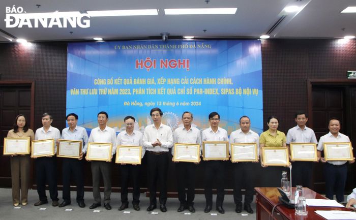 Phó Chủ tịch UBND thành phố Trần Chí Cường (thứ 6, trái sang) trao Bằng khen Chủ tịch UBND thành phố cho các đơn vị xuất sắc trong công tác văn thư lưu trữ năm 2023. Ảnh: TRỌNG HUY