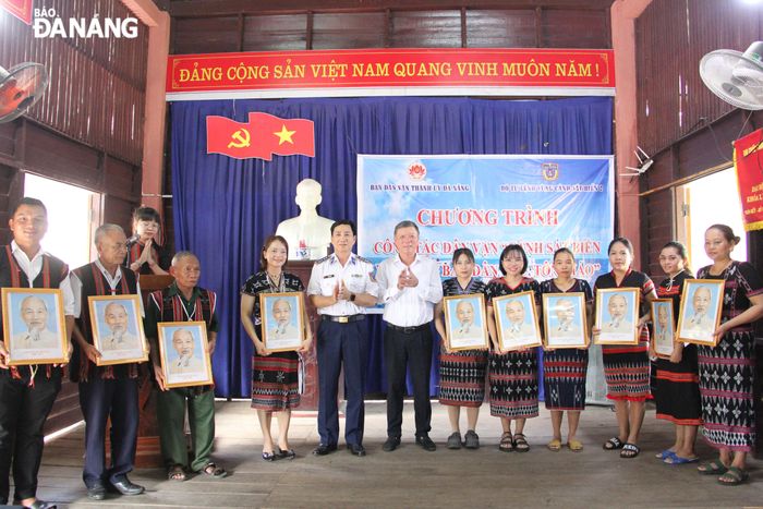Trưởng Ban Dân vận Thành ủy Lê Văn Trung (thứ 6, bên trái sang), Đại tá Lê Huy Sinh (thứ 5, bên trái sang) trao quà cho đồng bào tại thôn Tà Lang, xã Hòa Bắc, huyện Hòa Vang. Ảnh: X.H