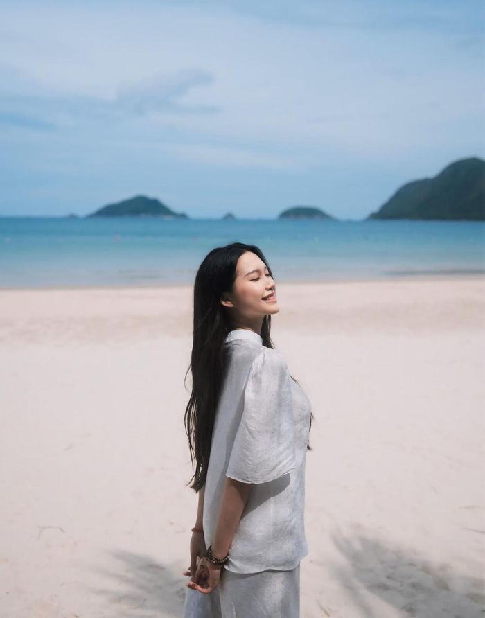 Vợ cầu thủ người Thái Bình mặc bộ cánh trắng cổ trụ, có đính hoa trước ngực đem lại cảm giác nền nã, thanh lịch. 