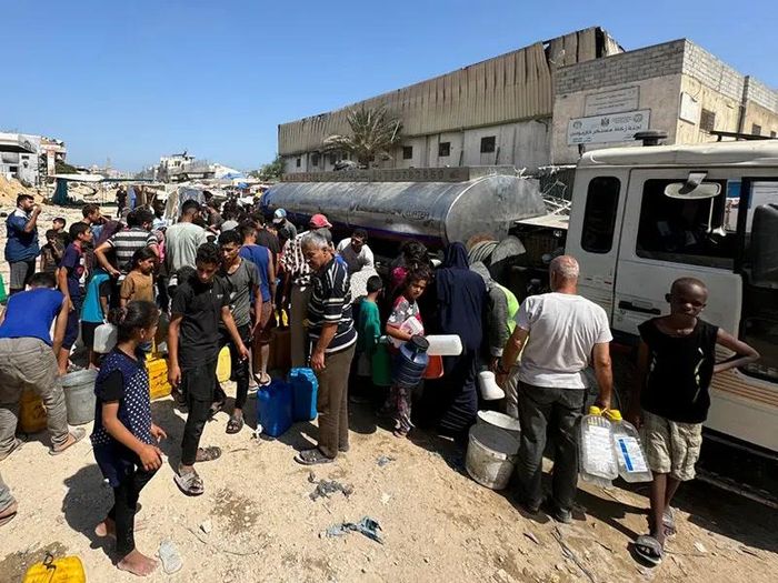 Người Palestine tụ tập để lấy nước trong bối cảnh khan hiếm nước ở Khan Younis. Ảnh: Mohammed Salem/Reuters.
