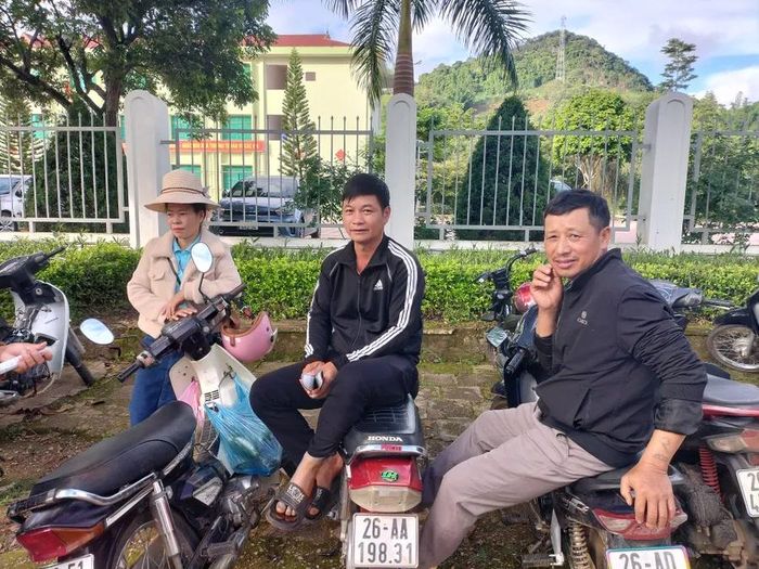 Phụ huynh học sinh ngồi ngoài cổng chờ con thi môn Toán.