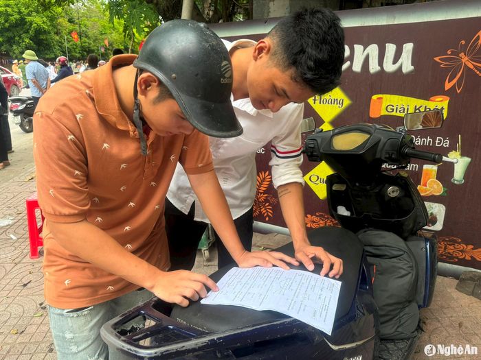 Nhiều thí sinh ở huyện Đô Lương nán lại điểm thi để trao đổi bài sau môn thi Toán. Ảnh: Ngọc Phương
