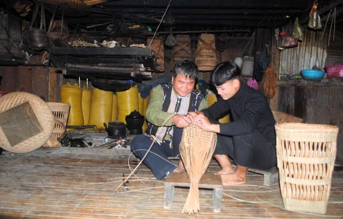 Khi rảnh việc, ông lại truyền nghề đan lát cho đứa con trai. Ảnh: N.V.S