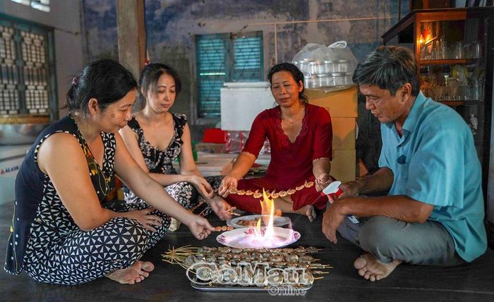 Trên bộ ván ngựa trong căn nhà xưa (xây dựng vào thập niên 70, thế kỷ XX), của gia đình anh Nguyễn Quốc Việt, ấp Tân Thành, xã Tân Tiến, huyện Đầm Dơi, mọi người quây quần cùng nhau thưởng thức món tôm lụi nướng rượu nếp, gợi nhớ lại một thời xa xưa.