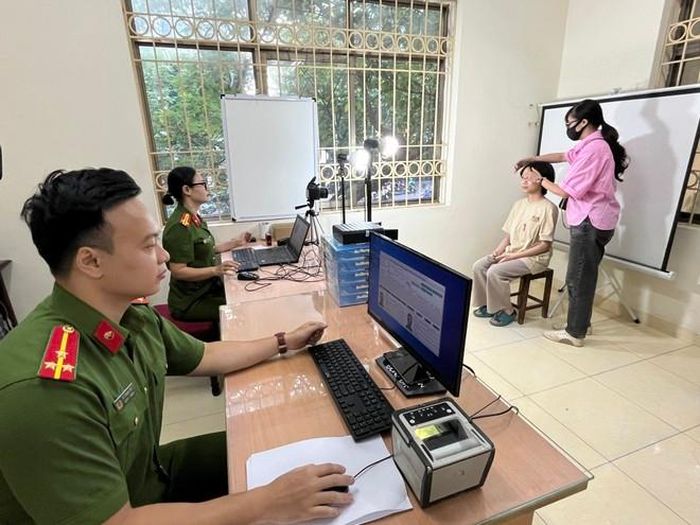 Các CBCS Công an quận Đống Đa thu nhận hình ảnh, mống mắt và vân tay của các công dân đến làm căn cước
