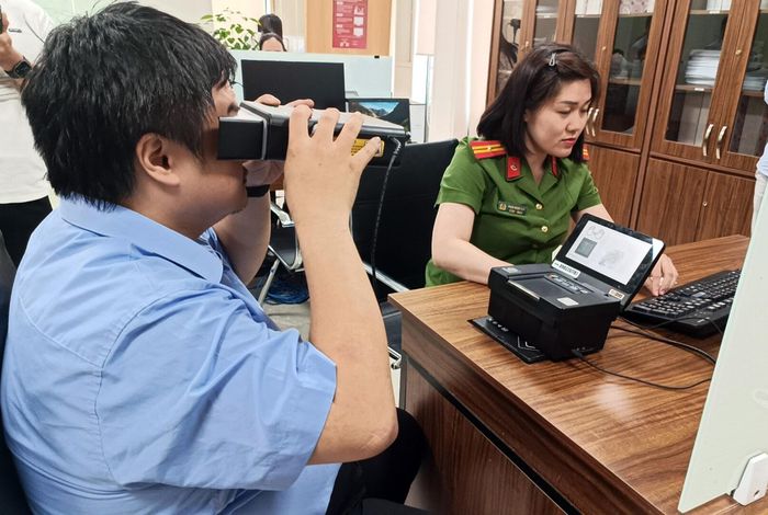 Người dân lấy sinh trắc học mống mắt trong khi làm thẻ căn cước.
