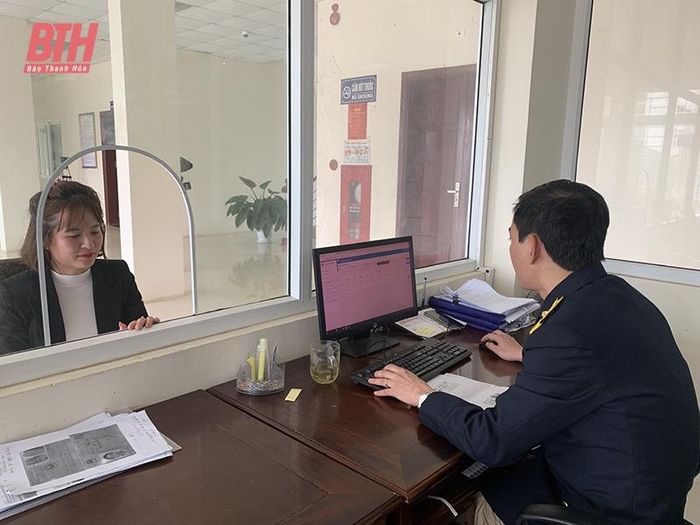 Cán bộ Chi cục Thuế khu vực Triệu Sơn - Nông Cống hướng dẫn người dân thủ tục nộp NSNN.