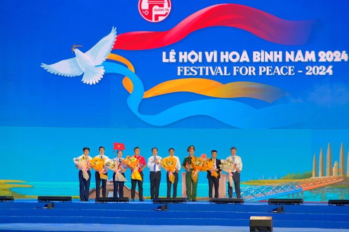 Phó Chủ tịch UBND tỉnh Hoàng Nam tặng hoa cho đại diện các tổ chức, đơn vị đồng hành với chương trình khai mạc Lễ hội Vì Hòa bình - Ảnh: Trần Tuyền