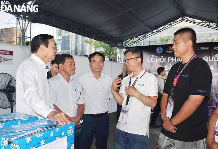 Chủ tịch UBND thành phố Lê Trung Chinh (bên trái) trò chuyện với đội pháo hoa đến từ Trung Quốc. Ảnh: THU HÀ