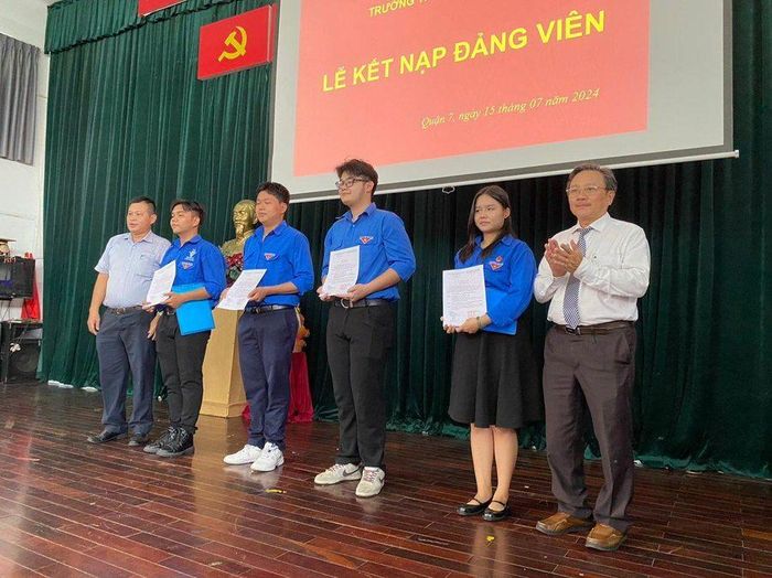  Ông Phan Hường – Hiệu trưởng, Bí thư Đảng bộ trao quyết định kết nạp Đảng cho 4 học sinh. (Ảnh: Hoàng Anh). 