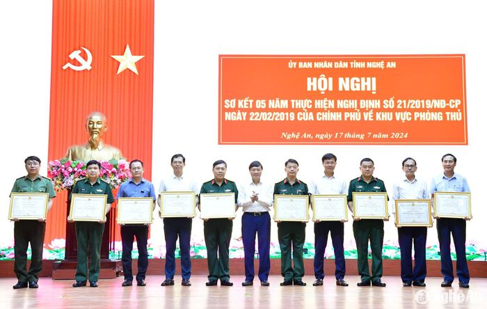 Đồng chí Lê Hồng Vinh trao Bằng khen cho 10 tập thể có thành tích xuất sắc trong việc thực hiện Nghị định số 21/2019/NĐ-CP của Chính phủ. Ảnh: Thành Chung