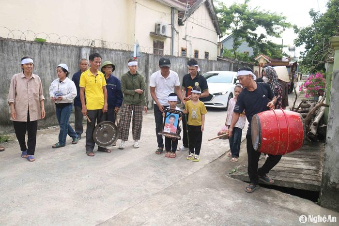 Hai con nhỏ của chị Bình và người thân trong lễ đưa tang chị Bình. Ảnh: Huy Thư