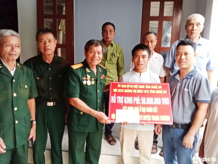 Thương binh Nguyễn Hữu Ất đại diện Hội Chiến sĩ thành cổ trao tiền hỗ trợ kinh phí xây nhà tình nghĩa cho đồng đội ở xã Thanh Lâm (Thanh Chương). Ảnh: NVCC