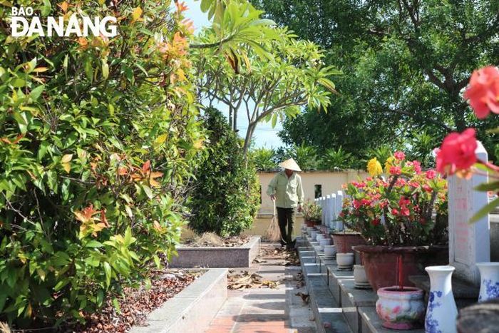 Ông Tình quét dọn lá cây - một trong những công việc hằng ngày của ông tại Nghĩa trang liệt sĩ xã Hòa Tiến (huyện Hòa Vang).