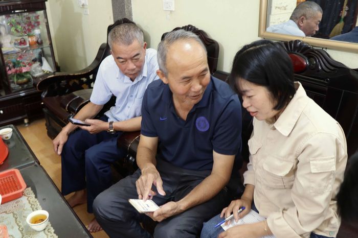 Lãnh đạo Nhà máy nước Tả Lèng và nhân viên trực tuyến thu ngân, Chi nhánh nước sạch thành phố Lai Châu hướng dẫn người dân thanh toán tiền nước qua ứng dụng trên điện thoại.