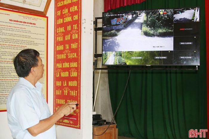 Ông Đặng Thế Đài xem camera an ninh của thôn qua ti vi thông minh.