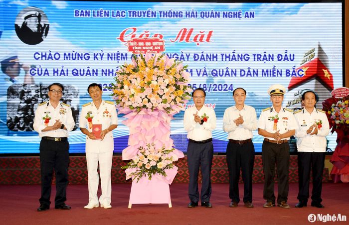 Đồng chí Nguyễn Nam Đình - Ủy viên Ban Thường vụ Tỉnh ủy, Phó Chủ tịch Thường trực Hội đồng nhân dân tỉnh tặng hoa chúc mừng Ban Liên lạc truyền thống Hải quân Nghệ An. Ảnh: Công Kiên