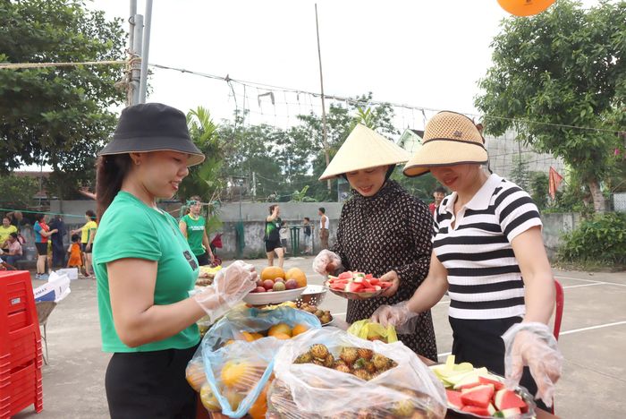 Chị em chuẩn bị hoa quả và nước uống cho khán giả đến xem thi đấu thể thao. Ảnh: Diệp Thanh