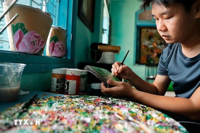  Sản phẩm được vẽ trang trí trên nền chất liệu lá sen. (Ảnh: Minh Quyết/TTXVN) 
