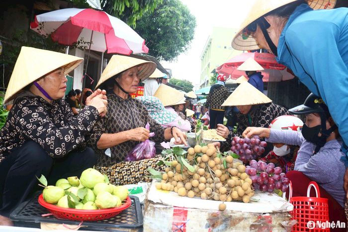 Hàng hoa, quả đông kẻ bán, người mua. Nhiều người dân khi đi chợ Rằm mua hoa, quả thường ưu tiên chọn mua cây trái vườn nhà, tuy không đẹp mã nhưng sạch, tươi ngon. Ảnh: Huy Thư