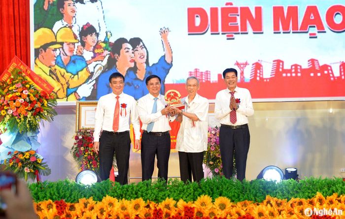 Ông Trương Đình Tuyển - nguyên Ủy viên Trung ương Đảng, nguyên Bộ trưởng Bộ Thương mại thay những mặt người con xa quê trao quà lưu niệm tặng Đảng bộ và nhân dân huyện Diễn Châu. Ảnh: Xuân Hoàng