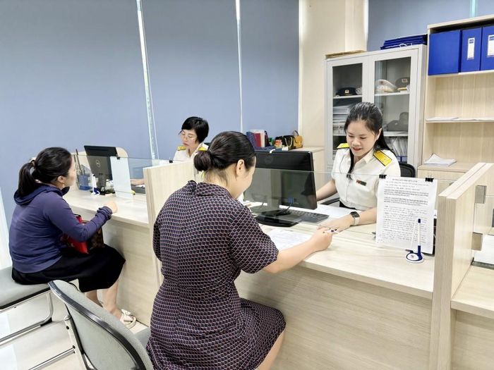 Công chức Chi cục Thuế khu vực Cẩm Phả - Vân Đồn - Cô Tô (Cục Thuế Quảng Ninh) hỗ trợ hộ kinh doanh thực hiện thủ tục kê khai thuế.