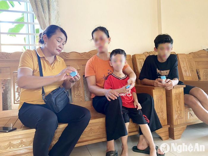 Chị Nguyễn Thị Mai - Chủ nhiệm CLB “Vòng tay nhân ái” ở xóm Bình Hạnh, xã Nghĩa Bình (Nghĩa Đàn) phát thuốc điều trị HIV cho thành viên CLB. Ảnh: Mai Phượng