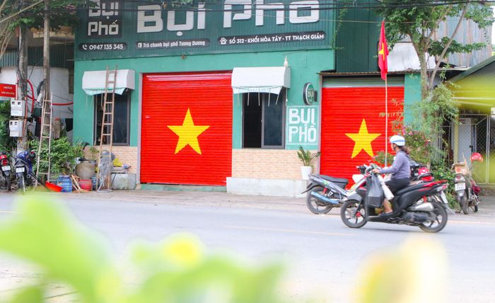 Một căn nhà của một hộ dân thuộc khối Hòa Tây, thị trấn Thạch Giám (Tương Dương) vừa treo cờ, vừa trưng hình vẽ quốc kỳ trên cửa cuốn, thể hiện tình yêu nước, lòng tự tôn dân tộc, hướng tới ngày Quốc khánh. Ảnh: Đình Tuân
