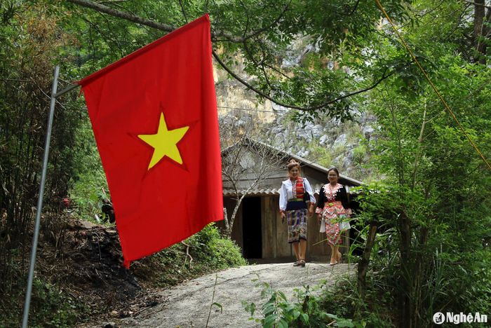 Trước những ngôi nhà truyền thống của người Mông, cờ Tổ quốc đỏ thắm tung bay trong nắng mùa Thu. Ảnh: Đào Thọ